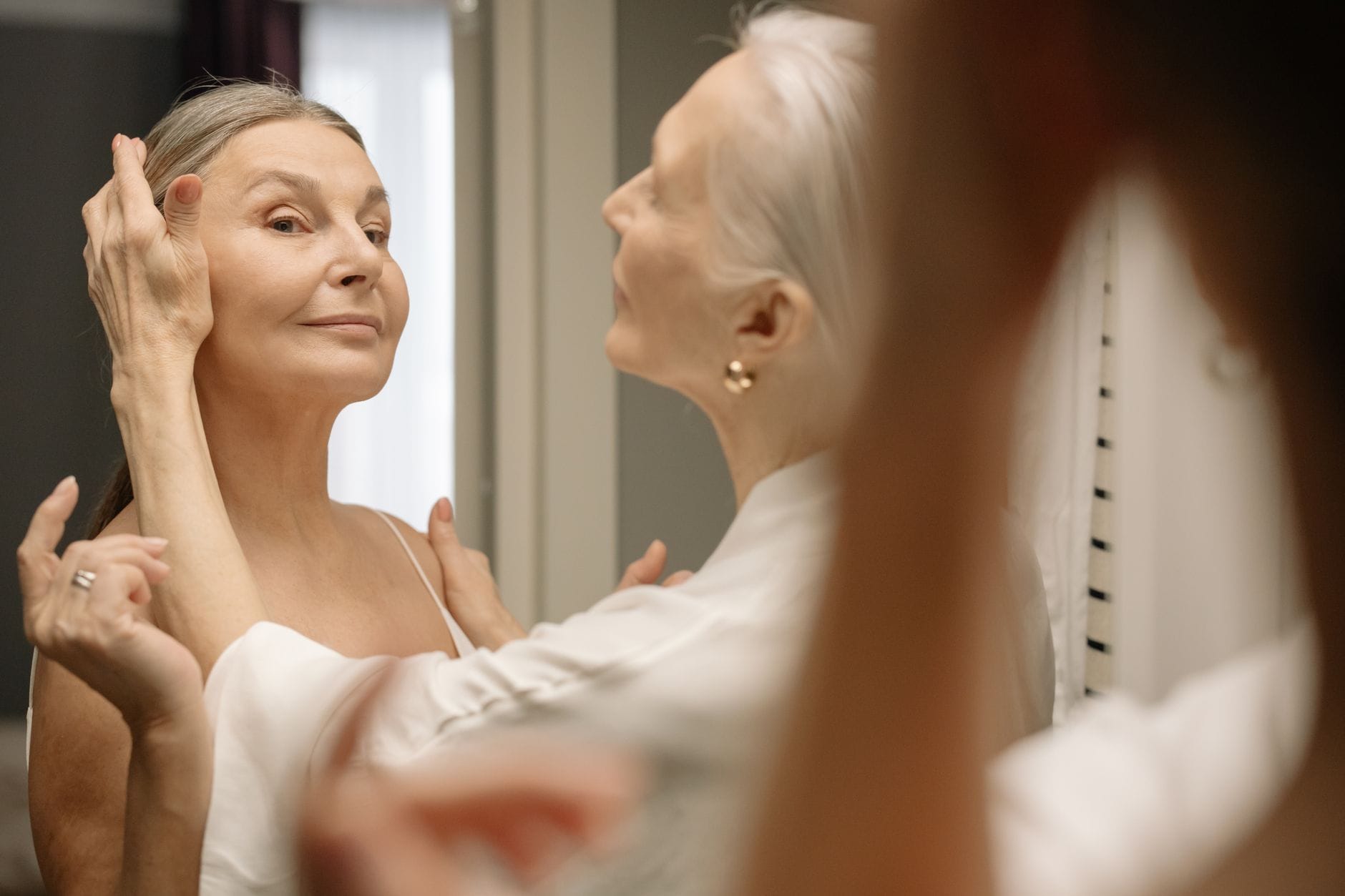 Elegancka starsza kobieta nakłada makijaż, pewna siebie po 50